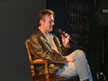 Anthony Head on a chair on stage