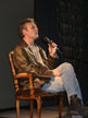 Anthony Head on a chair on stage