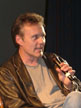 Anthony Head on a chair on stage