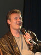 Anthony Head on a chair on stage