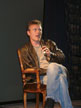 Anthony Head on a chair on stage