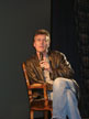 Anthony Head on a chair on stage