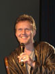 Anthony Head on a chair on stage