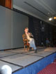 Anthony Head on a chair on stage