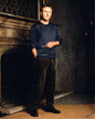 Tony in blue, standing in front of fireplace